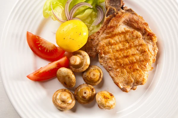 Grilled steaks, baked potatoes and vegetable salad — Stock Photo, Image