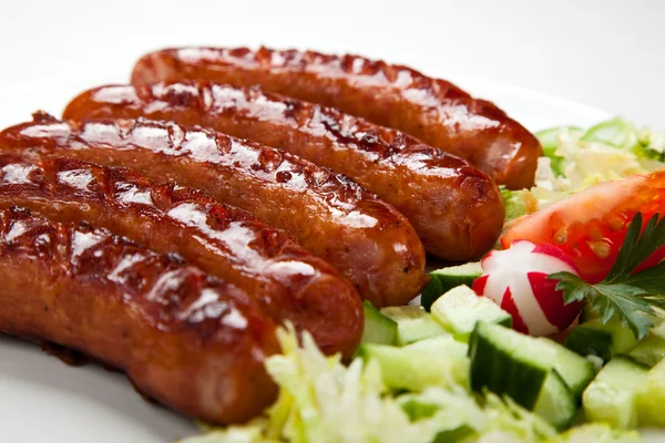 Grillade korvar med chips och grönsaker — Stockfoto