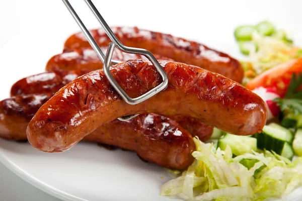 Grilled sausages with chips and vegetables — Stock Photo, Image