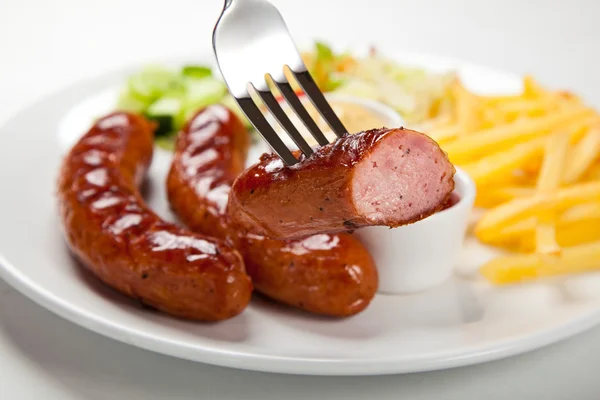 Grillade korvar med chips och grönsaker — Stockfoto