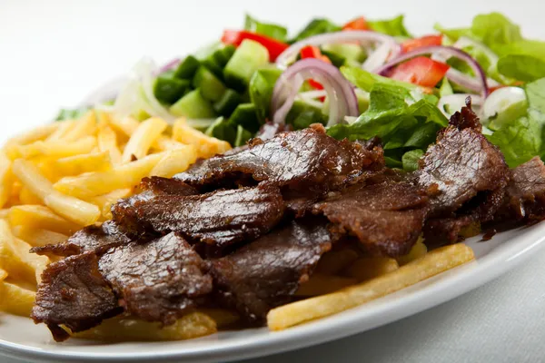 Carne a la parrilla con patatas fritas y ensalada de verduras —  Fotos de Stock