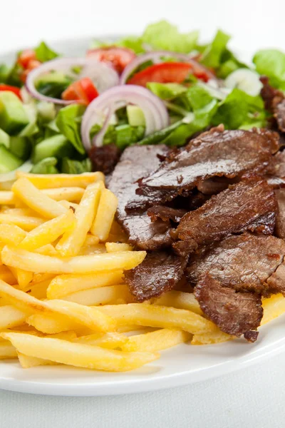 Carne alla griglia con patate fritte e insalata di verdure — Foto Stock