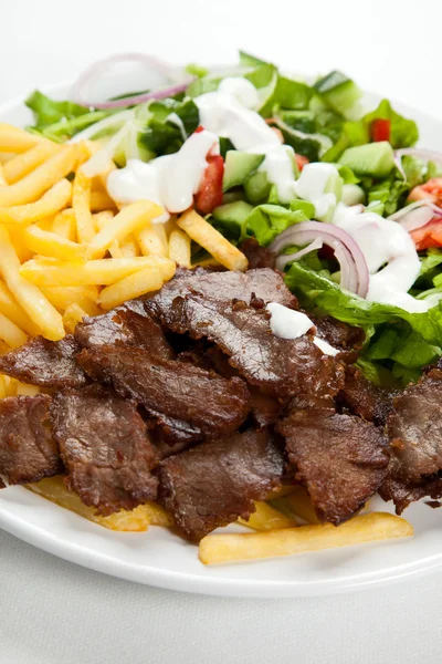 Grillat kött med stekt potatis och grönsakssallad — Stockfoto