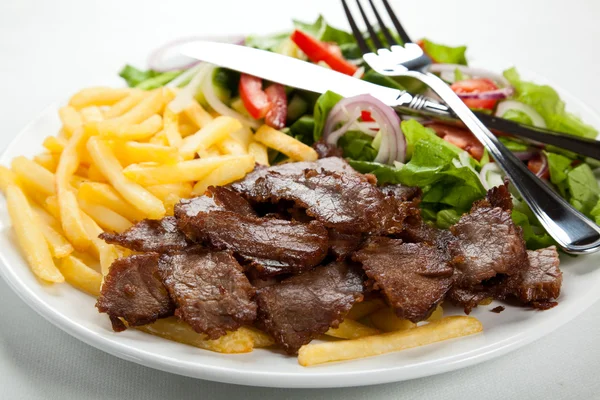 Carne a la parrilla con patatas fritas y ensalada de verduras —  Fotos de Stock