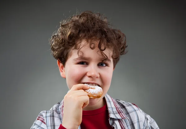 Junge isst süßen Donut — Stockfoto