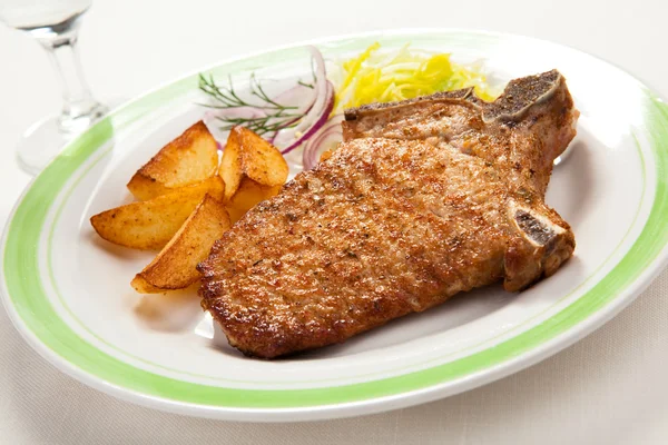 Carne de porco grelhada, batatas fritas e salada de legumes — Fotografia de Stock