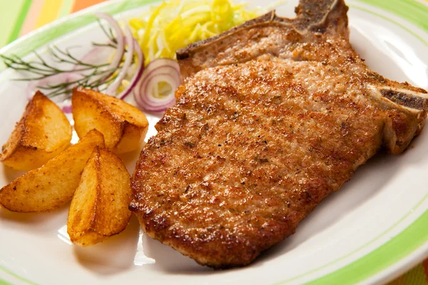 Grilled chop pork, chips and vegetable salad — Stock Photo, Image