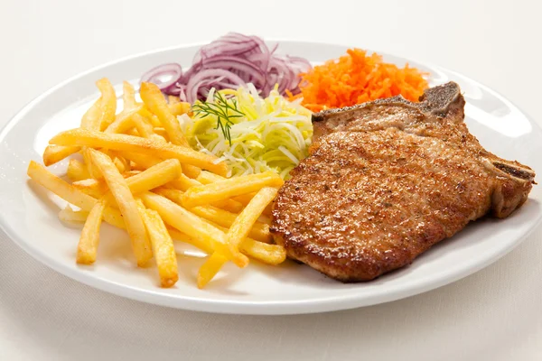 Gegrilde hakken varkensvlees, Franse frietjes en plantaardige salade — Stockfoto