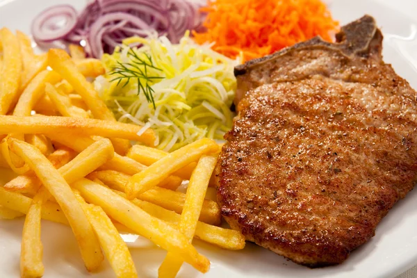 Izgara pirzola domuz eti, patates ve sebze salatası — Stok fotoğraf