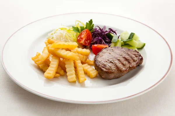 Grilled steaks, chips and vegetables — Stock Photo, Image