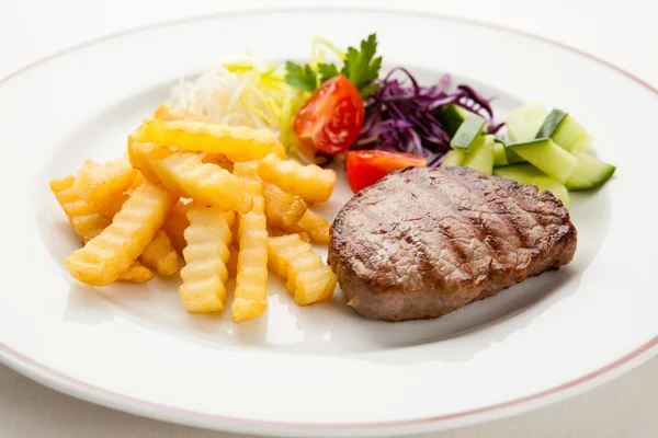 Steaks grillés, croustilles et légumes — Photo