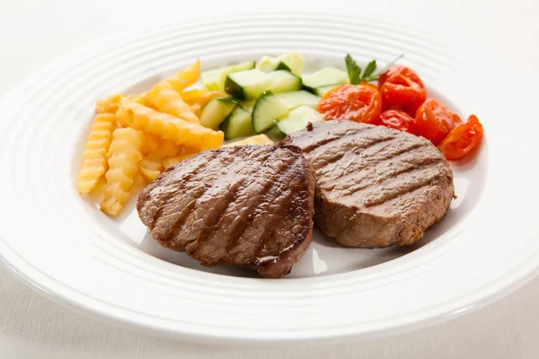 Gegrilde steaks, chips en groenten — Stockfoto