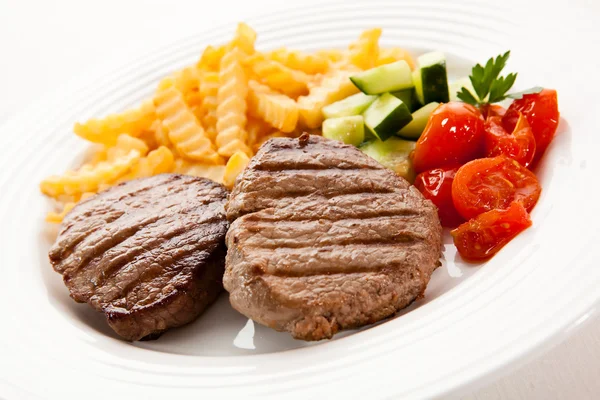 Steaks grillés, croustilles et légumes — Photo