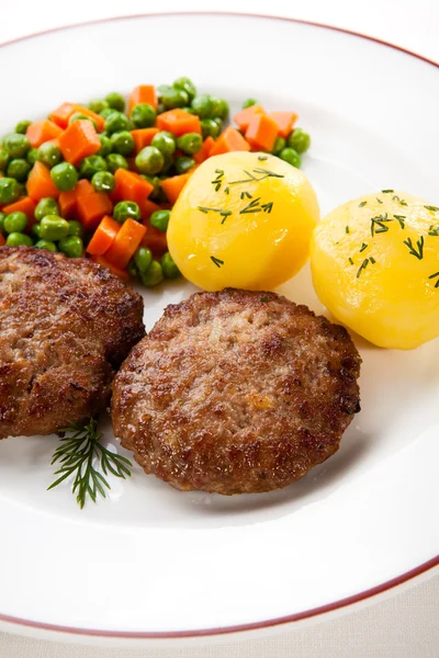 Fried pork chops with boiled potatoes and vegetables — Stock Photo, Image