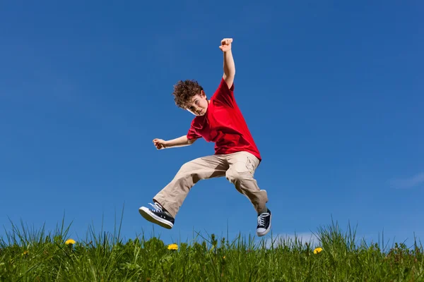 Jongen buiten springen — Stockfoto