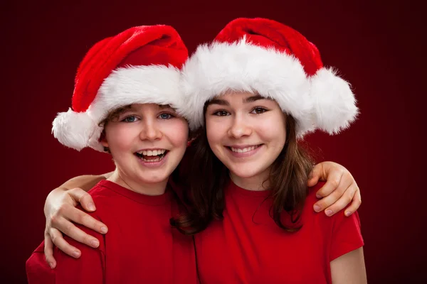 Menino e menina com Papai Noel Chapéus — Fotografia de Stock