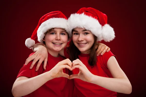 Menino e menina com Papai Noel Chapéus — Fotografia de Stock