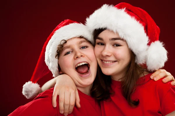 Niño y niña con Santa Claus Sombreros —  Fotos de Stock