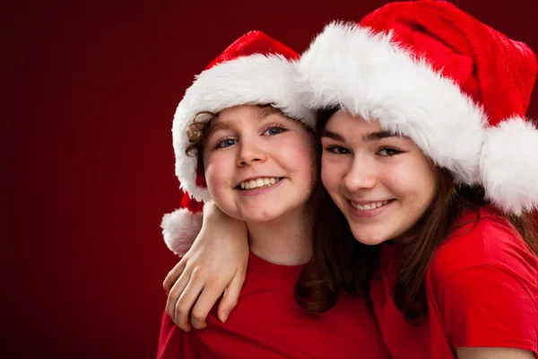 Niño y niña con Santa Claus Sombreros —  Fotos de Stock