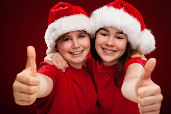 Pojke och flicka med santa claus hattar — Stockfoto