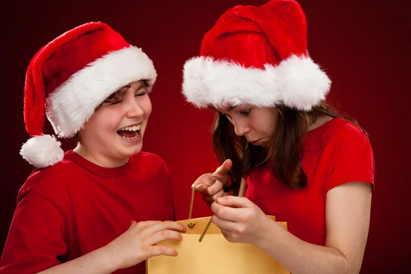 Мальчик и девочка в шляпах Санта-Клауса — стоковое фото