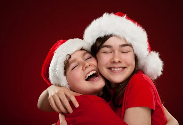 Pojke och flicka med santa claus hattar — Stockfoto