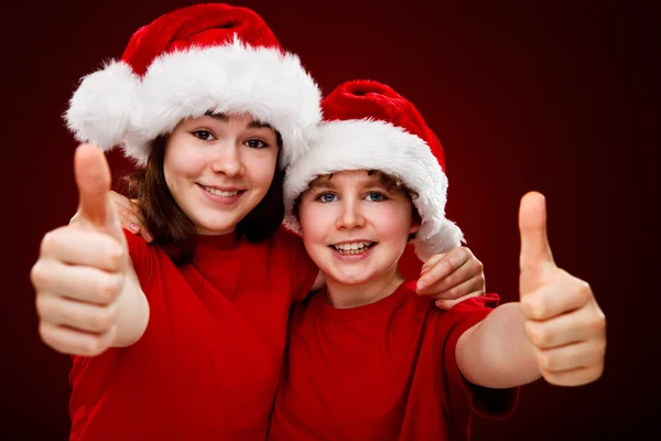 Niño y niña con Santa Claus Sombreros — Foto de Stock
