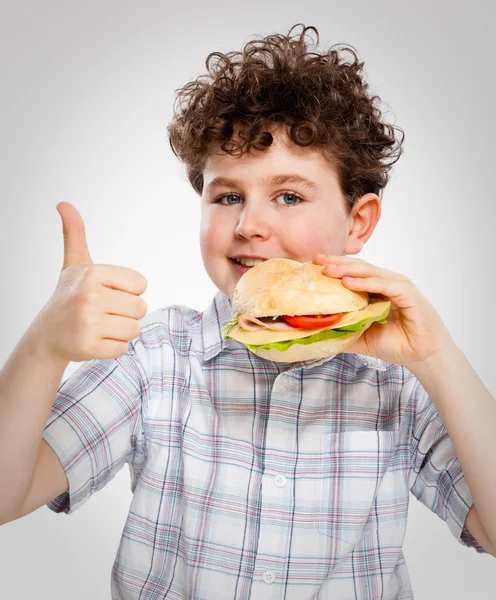 Menino comendo sanduíche grande — Fotografia de Stock