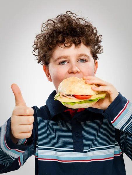 少年は、大きなサンドイッチを食べて — ストック写真