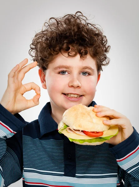 Menino comendo sanduíche grande — Fotografia de Stock