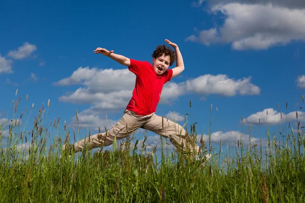 Niño saltando contra el cielo azul —  Fotos de Stock