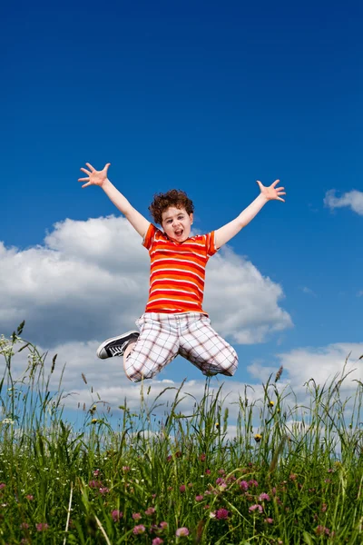 Niño saltando contra el cielo azul — Foto de Stock