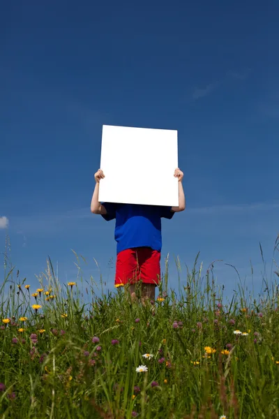 Мальчик держит пустую доску объявлений — стоковое фото