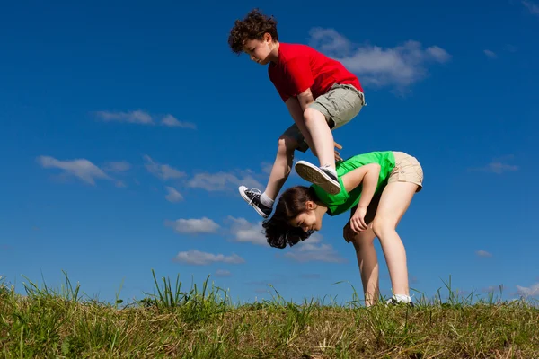 Chica y niño saltando, corriendo — Foto de Stock