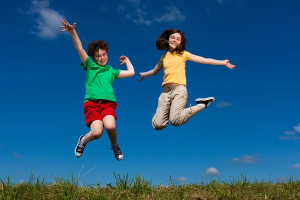 여자와 소년 점프 야외 — 스톡 사진