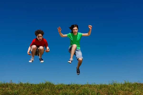 女の子と男の子の屋外ジャンプ — ストック写真