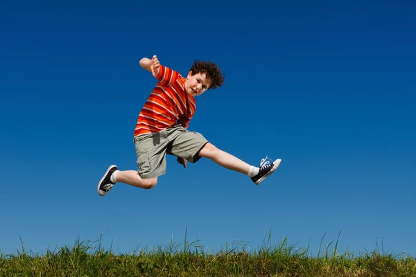 男孩跳、 蓝蓝的天空针对运行 — 图库照片