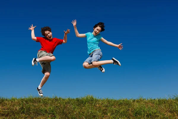 Mädchen und Junge springen — Stockfoto