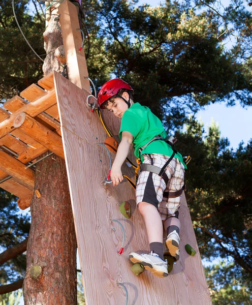 Menino escalando no parque de aventura — Fotografia de Stock