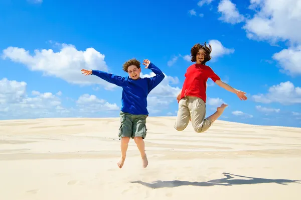 Barnen hoppar mot blå himmel — Stockfoto