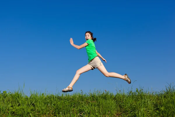 Menina saltando contra o céu azul — Fotografia de Stock