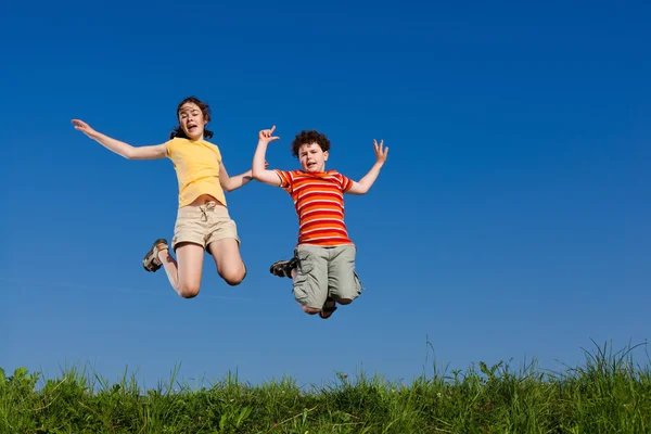 Girl and boy jumping Stock Image