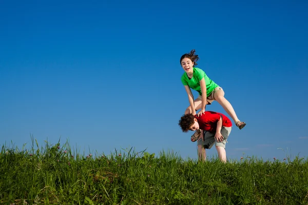 Girl and boy jumping, running — Stockfoto
