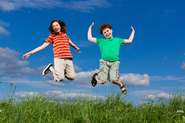 Meisje en jongen springen — Stockfoto