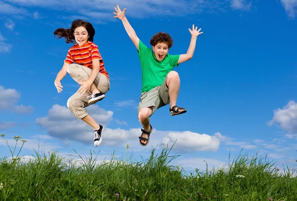 Girl and boy jumping — Stock Photo, Image