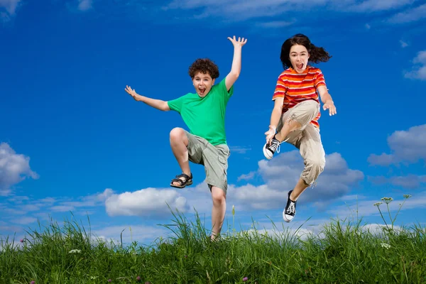 Menina e menino pulando — Fotografia de Stock