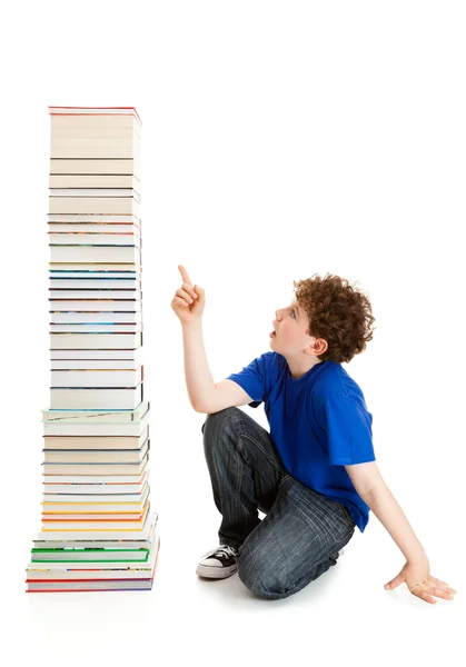 Estudante perto da pilha de livros — Fotografia de Stock