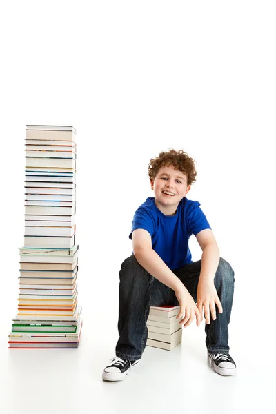 Estudante perto da pilha de livros — Fotografia de Stock