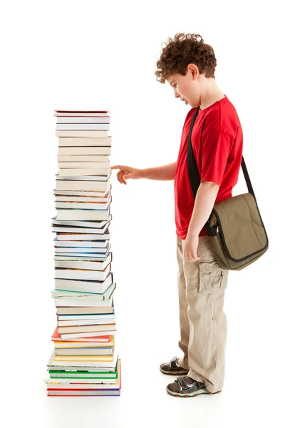 Niño de pie cerca de la pila de libros —  Fotos de Stock