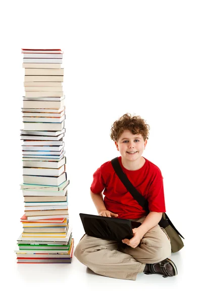 Junge sitzt dicht an Bücherstapel — Stockfoto